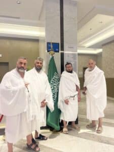 Pèlerins Gate Away en ihram devant le drapeau saoudien avant l'Omra